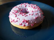 A white with pink donut on the blue plate macro view stock photos A white with pink donut on the blue plate macro view stock photos