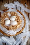 White eggs in a decorative nest on a wooden plate. Easter concept Easter mood stock photo White eggs in a decorative nest on a wooden plate. Easter concept Easter mood stock photo
