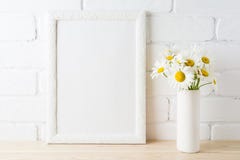 White frame mockup with daisy flower near painted brick wall Stock Images White frame mockup with daisy flower near painted brick wall Stock Images