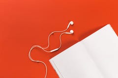 White headphones and a mocup magazine on a red background royalty free stock photo White headphones and a mocup magazine on a red background royalty free stock photo
