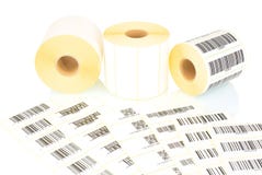 White label rolls and printed barcodes isolated on white background with shadow reflection. White reels of labels for printers. royalty free stock image White label rolls and printed barcodes isolated on white background with shadow reflection. White reels of labels for printers. royalty free stock image