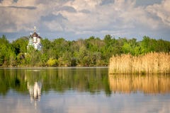 A white orthodox church reflecting in the water. stock photo A white orthodox church reflecting in the water. stock photo