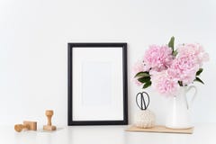 White portrait frame mock up with a pink peonies beside the frame