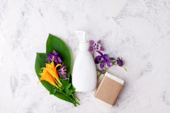 White soap or cream dispenser, leaves and flowers on white background, Organic cosmetic products mock up and herb. Skin Care.