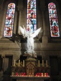 A white stone angel and story-telling glass behind inside the Sacré-Cœur, Paris royalty free stock photos A white stone angel and story-telling glass behind inside the Sacré-Cœur, Paris royalty free stock photos