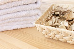 White towels and basket with spicy dry plants on a light wooden background stock image White towels and basket with spicy dry plants on a light wooden background stock image