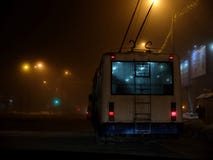 White trolleybus driving dangerously in the fog at night stock photo White trolleybus driving dangerously in the fog at night stock photo