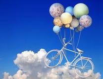 Vintage bicycle flying up into the sky with balloons