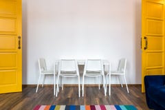 White wooden chairs with a table against the background of a white wall in the interior with yellow doors royalty free stock photos White wooden chairs with a table against the background of a white wall in the interior with yellow doors royalty free stock photos
