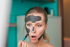 White young woman wearing a face mask at home on a turquoise background. European woman in black mask for the face close up and c royalty free stock photos White young woman wearing a face mask at home on a turquoise background. European woman in black mask for the face close up and c royalty free stock photos