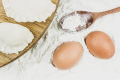 Whole egg and wooden spoon on flour background. stock photos Whole egg and wooden spoon on flour background. stock photos
