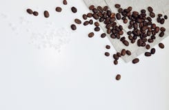 Whole grains of roasted black coffee scattered on a linen towel stock photo Whole grains of roasted black coffee scattered on a linen towel stock photo