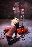 Whole pork tenderloin meat on vintage board with tomatoes and garlic Stock Photo Whole pork tenderloin meat on vintage board with tomatoes and garlic Stock Photo