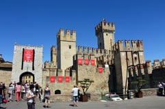 Widok średniowieczny Scaliger kasztel Sirmione z signboard włocha wiec Mille Miglia i łodzi motorowa omijanie, Sirmione zdjęcie stock Widok średniowieczny Scaliger kasztel Sirmione z signboard włocha wiec Mille Miglia i łodzi motorowa omijanie, Sirmione zdjęcie stock