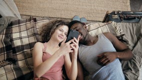 Wieloetniczny pary lying on the beach na łóżku i używać smartphone Mężczyzna i kobieta szczęśliwi wpólnie Samiec i żeński śmiać s zdjęcie wideo Wieloetniczny pary lying on the beach na łóżku i używać smartphone Mężczyzna i kobieta szczęśliwi wpólnie Samiec i żeński śmiać s zdjęcie wideo