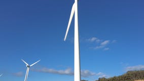 Wind energy turbines on blue sky background, sustainable ecological energy production. stock footage Wind energy turbines on blue sky background, sustainable ecological energy production. stock footage