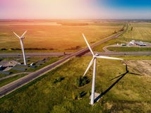 Wind turbines and solar panels in huge green field surrounded by highway stock image Wind turbines and solar panels in huge green field surrounded by highway stock image