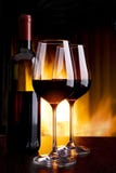 Wine dal vetro contro il camino con fuoco Wine dal vetro contro il camino con fuoco