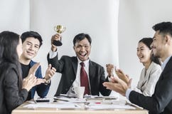 Winning business team with a man executive holding a gold trophy Stock Photography Winning business team with a man executive holding a gold trophy Stock Photography