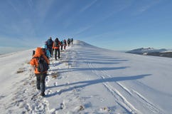 Mountain hiking in winter. Group of hikers on mountain track