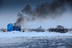 Winteransicht der deutschen Behälter panzers im Angriff mit brennendem Haus lizenzfreie stockbilder Winteransicht der deutschen Behälter panzers im Angriff mit brennendem Haus lizenzfreie stockbilder