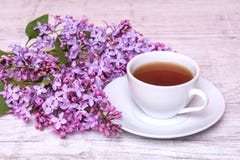 Witte kop met koffie of thee en een boeket van seringen op een houten achtergrond stock foto's Witte kop met koffie of thee en een boeket van seringen op een houten achtergrond stock foto's