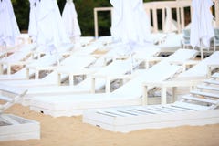 Witte poolstoelen op zandstrand royalty-vrije stock afbeeldingen Witte poolstoelen op zandstrand royalty-vrije stock afbeeldingen