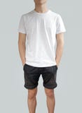 Witte t-shirt en zwarte borrels op een jonge mensenmalplaatje op grijze B Royalty-vrije Stock Foto's Witte t-shirt en zwarte borrels op een jonge mensenmalplaatje op grijze B Royalty-vrije Stock Foto's