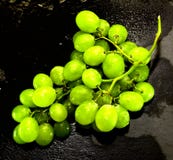 Wiązka winogrona na czarnym łupku kamieniu Obrazy Stock Wiązka winogrona na czarnym łupku kamieniu Obrazy Stock