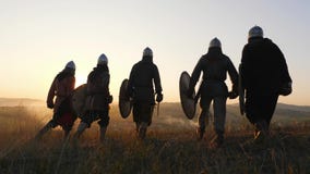 Wojownicy Vikings iść i stoping w polu i spojrzeniu przy pięknym zmierzchem zbiory wideo Wojownicy Vikings iść i stoping w polu i spojrzeniu przy pięknym zmierzchem zbiory wideo