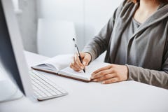 Wolę starej szkoły writing metodę Cropped portret robi notatkom w notatniku ruchliwie kobieta, patrzeje ekran komputerowego obraz royalty free Wolę starej szkoły writing metodę Cropped portret robi notatkom w notatniku ruchliwie kobieta, patrzeje ekran komputerowego obraz royalty free