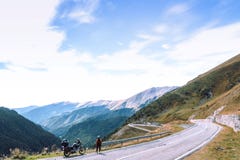 Woman with adventure motorcycle. Motorbike rider. Top of mountain road. Motorcyclists vacation. Travel and active lifestyle. Transfagarasan Romaia, copy space royalty free stock photos Woman with adventure motorcycle. Motorbike rider. Top of mountain road. Motorcyclists vacation. Travel and active lifestyle. Transfagarasan Romaia, copy space royalty free stock photos