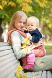 Woman And Cute Baby With Leafs Sitting On Bench Royalty Free Stock Photo