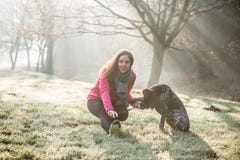 Woman And Her Dog Stretching Outdoor. Fitness Girl And Her Pet Working Out Together. Royalty Free Stock Photos