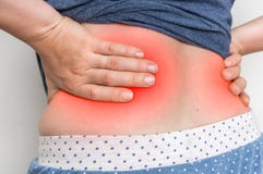 Woman with back pain touching her aching back stock photo Woman with back pain touching her aching back stock photo