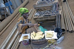 Woman baking bananas along the street and selling them. royalty free stock image Woman baking bananas along the street and selling them. royalty free stock image
