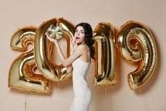 Portrait Of Beautiful Smiling Girl In Shiny Golden Dress Throwing Confetti, Having Fun With Gold 2019 Balloons On Background. royalty free stock photos Portrait Of Beautiful Smiling Girl In Shiny Golden Dress Throwing Confetti, Having Fun With Gold 2019 Balloons On Background. royalty free stock photos