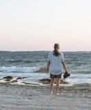 Woman on Beach at Dawn Gazing out to sea stock photos Woman on Beach at Dawn Gazing out to sea stock photos