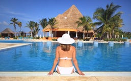 Woman in a bikini by beach resort swimming pool