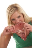 Woman Biting A Raw Steak Stock Image
