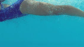 Woman in blue bathing suit swimming underwater