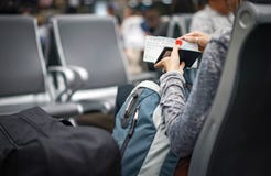 The woman checks her passport and plane ticket in the hand and waiting the plane in an international airport, Thailand royalty free stock images The woman checks her passport and plane ticket in the hand and waiting the plane in an international airport, Thailand royalty free stock images
