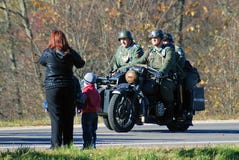 A woman and children look at three military men in retro uniform