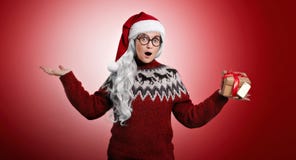 Woman in Christmas sweater and Santa hat with presents royalty free stock photography Woman in Christmas sweater and Santa hat with presents royalty free stock photography