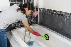Woman cleaning bathtub with brush stock image Woman cleaning bathtub with brush stock image