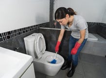 Woman cleaning toilet bowl with brush stock images Woman cleaning toilet bowl with brush stock images