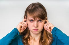 Woman closes ears with fingers to protect from loud noise stock photos Woman closes ears with fingers to protect from loud noise stock photos