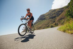 Woman competing in the cycling leg of a triathlon royalty free stock photography Woman competing in the cycling leg of a triathlon royalty free stock photography