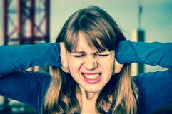 Woman covering her ears to protect from loud noise stock photography Woman covering her ears to protect from loud noise stock photography