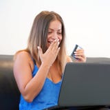 Woman with a credit card at home. A young girl buys online. A woman is holding a credit card and is using a laptop. The concept of stock photos Woman with a credit card at home. A young girl buys online. A woman is holding a credit card and is using a laptop. The concept of stock photos